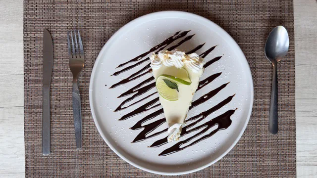 Rebanada de pay de limón con crema batida y chocolate en plato blanco